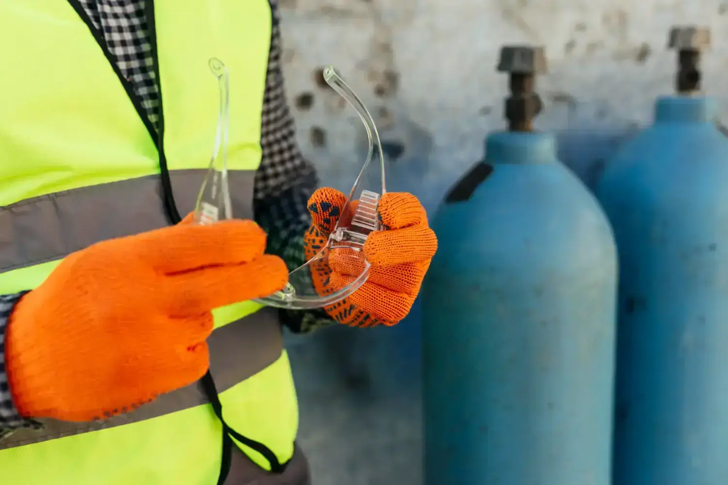 worker-with-gloves-holding-protective-glasses